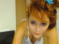 A red haired teen is naked while chatting on her webcam