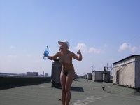 Two gals sunbathing nude at roof
