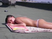 Two gals sunbathing nude at roof