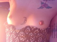 Nerdy tattooed goth girl shows her piercings and holes