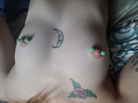Nerdy tattooed goth girl shows her piercings and holes