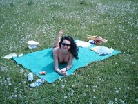 Amateur brunette sunbathing topless