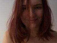 Curvy redhead with pierced nipples nude posing