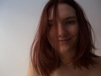 Curvy redhead with pierced nipples nude posing