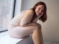 Curvy redhead with pierced nipples nude posing