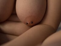 Curvy redhead with pierced nipples nude posing