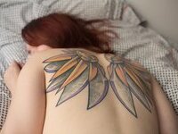 Curvy redhead with pierced nipples nude posing